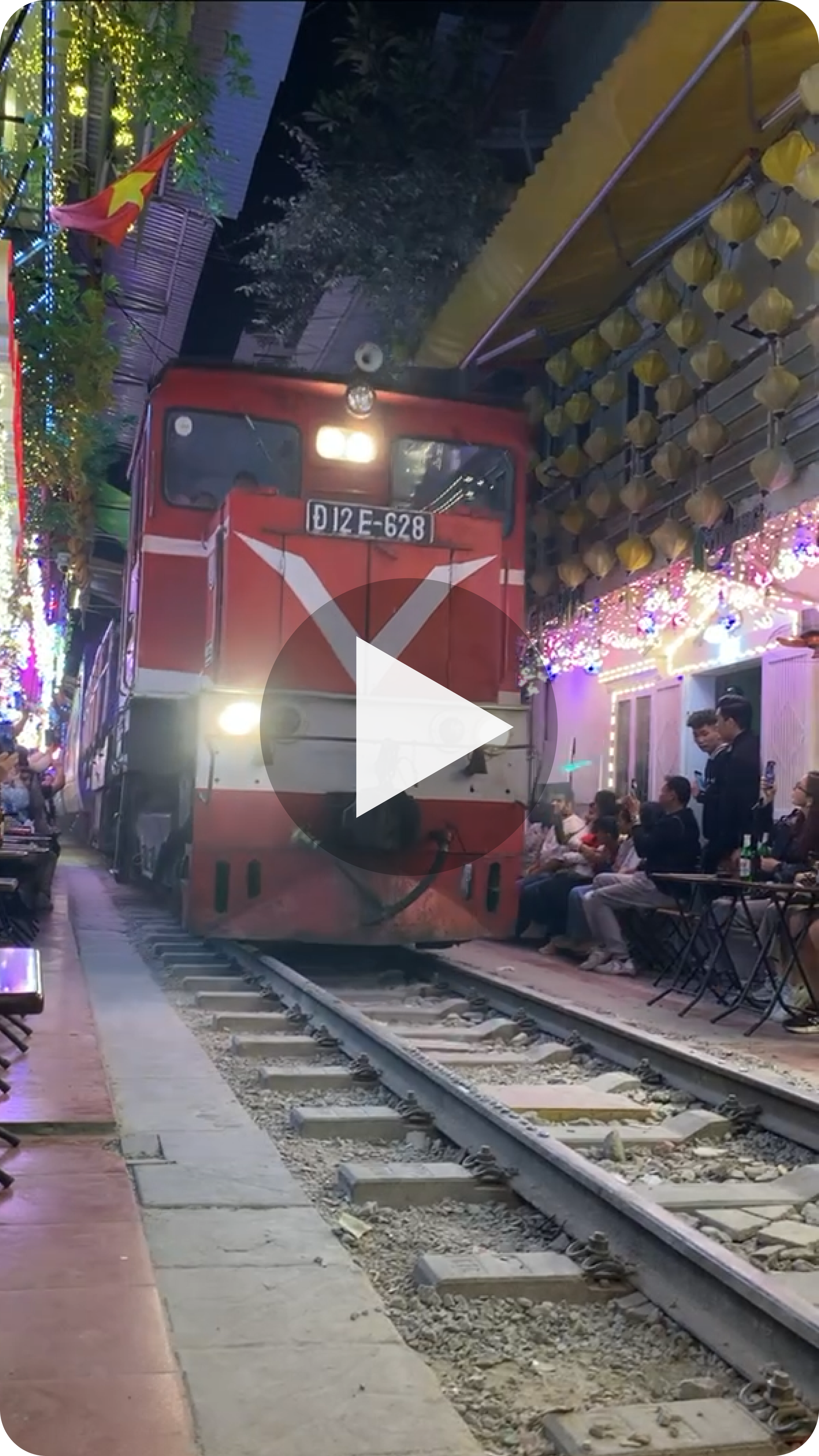 Play Nikki's Moment: a train passing the cafes on Hanoi's Train Street at night