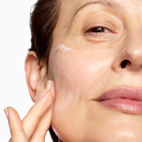 Close up of model moisturising face