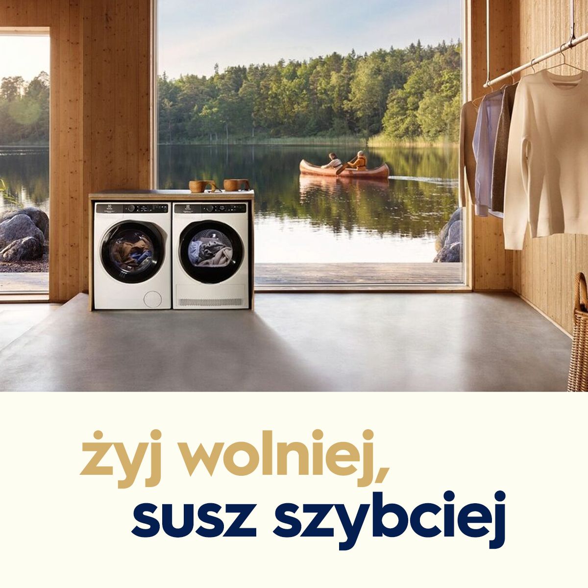 Żyj wolniej, pierz szybciej. Pralka i suszarka na tle dużego okna przez które widać mężczyznę i kobietę płynących kajakiem